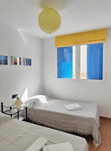 a bedroom with two beds and a large window at Pita 2 in La Isleta del Moro