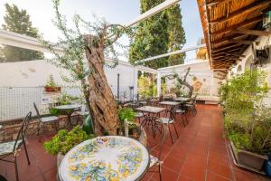 a patio with tables and chairs and a tree at Taormina Garden Hotel in Taormina