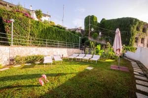 a patio with chairs and an umbrella and pink flamingos at Taormina Garden Hotel in Taormina