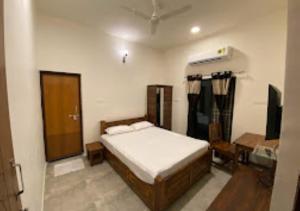 a bedroom with a bed and a desk in it at Erisha Tadoba Chandrapur in Mohurli