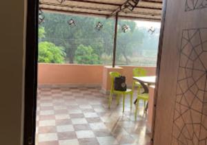 a room with a table and chairs and a window at Erisha Tadoba Chandrapur in Mohurli