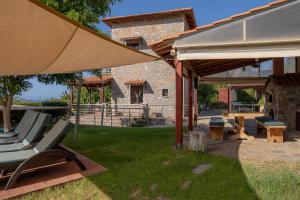 a patio with chairs and an umbrella and a table at Villa Iris in Milatos
