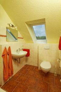 uma casa de banho com um lavatório, um WC e uma janela. em Haus Clara Wohnung 07 em Ostseebad Koserow