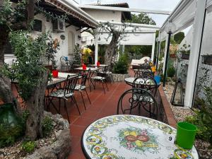an outdoor patio with tables and chairs and a table at Taormina Garden Hotel in Taormina