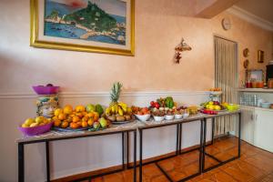 a table filled with fruits and vegetables in a room at Taormina Garden Hotel in Taormina