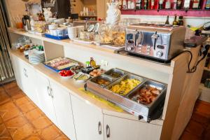 un buffet con muchos platos de comida en una barra en Taormina Garden Hotel, en Taormina