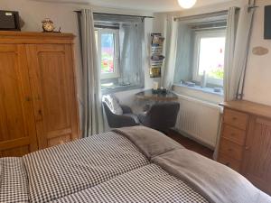 una camera da letto con un letto, una sedia e finestre di Burgweg Ferienwohnung a Veringenstadt