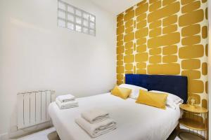 um quarto com uma cama amarela e branca em Magnifique 3 pièces au cœur du haut Marais em Paris