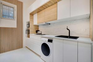 uma cozinha com uma máquina de lavar roupa e um lavatório em Magnifique 3 pièces au cœur du haut Marais em Paris