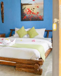 1 dormitorio con 1 cama con una pintura en la pared en Gading Tree House, en Nusa Penida