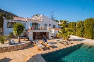 eine Villa mit Swimmingpool und ein Haus in der Unterkunft Villa Teranga - PlusHolidays in Benissa
