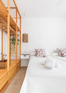 two beds in a bedroom with white walls and wooden cabinets at Marce in Ciutadella