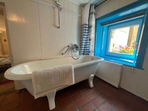 y baño con bañera y ventana. en Burgweg Ferienwohnung, en Veringenstadt