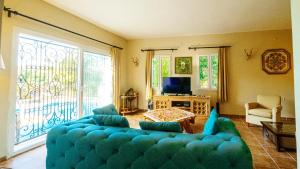 オータキャンツにあるSalmakis Villasのリビングルーム(青いソファ、テレビ付)