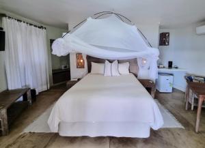 a bedroom with a white bed with a canopy at The Nautilus Pemba in Pemba