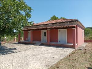 una pequeña casa rosa con entrada en Stammys house en Pelekas