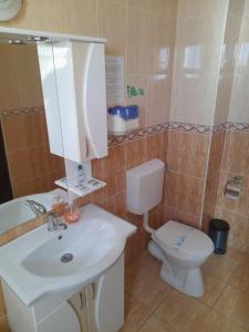 uma casa de banho com um lavatório branco e um WC. em Pensiunea Crown Royal em Alba Iulia