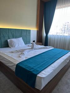 a bedroom with a large bed with a blue blanket at Kançul Hotel Taştepeler in Urfa