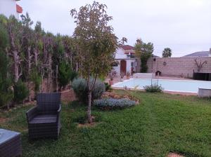 un patio con una silla y una piscina en El Torreon Vacacional, en Mairena del Alcor