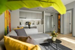 sala de estar con sofá y cocina en Luxury Apartment near Radisson Hotel - Wall Projector & Modern Design, en Bucarest