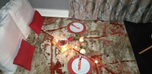 una mesa con platos de comida y velas en una cama en Kingsworth inn Port Elizabeth en Puerto Elizabeth