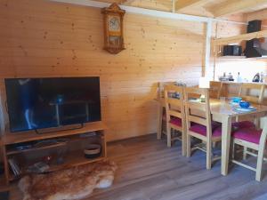 ein Esszimmer mit einem TV und einem Tisch mit Stühlen in der Unterkunft Bercikówka in Łabowa
