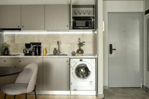 a kitchen with a washing machine in a kitchen at Luxury Apartment near Radisson Hotel - Wall Projector & Modern Design in Bucharest