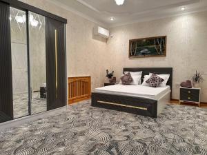 um quarto com uma cama e uma grande janela em VILLA ANOR em Yakkasaray