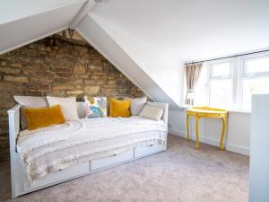 Cama blanca en habitación con pared de piedra en Pass the Keys Quarry Cottage Courtyard Garden, en Cirencester
