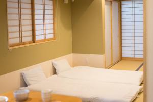 Una cama o camas en una habitación de Guesthouse ZenNichi