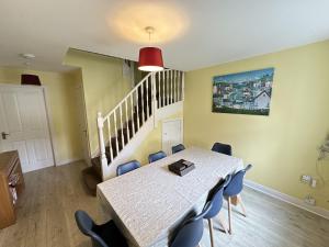 a dining room with a table and blue chairs at Greenwich Cottage - Part of the The Bay Filey Holiday Village with pool, gym and direct beach access, pub, restaurant, tennis and meadows walks in Reighton