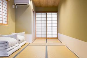 two beds in a room with a window at Guesthouse ZenNichi in Kyoto
