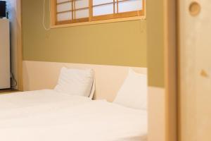 Una cama o camas en una habitación de Guesthouse ZenNichi