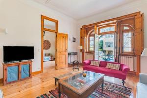 een woonkamer met een rode bank en een tv bij Estoril Historical Villa by the Sea in Estoril