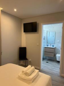 豐沙爾的住宿－Ocean Paradise do Til，一间卧室设有一张带电视的床和一间浴室。