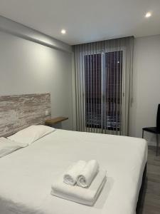 a bedroom with a white bed with towels on it at Ocean Paradise do Til in Funchal