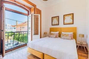 1 dormitorio con cama grande y ventana grande en Estoril Historical Villa by the Sea en Estoril