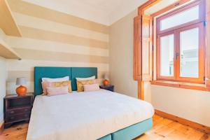 - une chambre avec un grand lit et une fenêtre dans l'établissement Estoril Historical Villa by the Sea, à Estoril