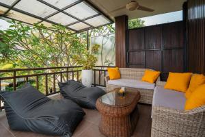 un patio avec deux canapés et une table sur un balcon dans l'établissement Villa Balika 2, à Canggu