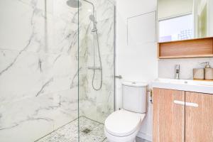 ein Bad mit einem WC und einer Glasdusche in der Unterkunft Appartement Parisien Porte d'Ivry in Ivry-sur-Seine