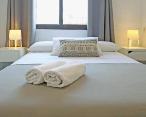 1 dormitorio con 2 camas y toallas. en Hostal Costa, en Ibiza