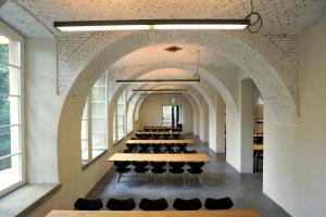 a row of tables in a room with windows at Basel Youth Hostel in Basel