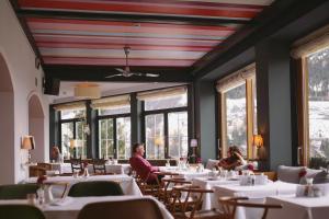 jadalnia ze stołami i ludzie siedzący przy stołach w obiekcie Alpine Spa Hotel Haus Hirt w mieście Bad Gastein