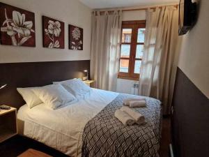 a bedroom with a bed with two towels on it at Ático acogedor centro de Canillo in Canillo
