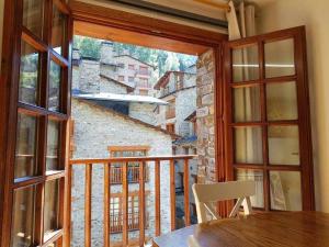 a room with a large window and a table and chair at Ático acogedor centro de Canillo in Canillo