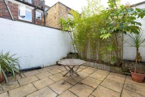 a patio with a table in front of a fence at Spacious 4BR 3-Storey Townhouse in Lively Deptford in London