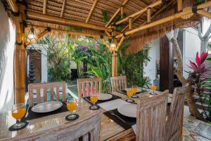 - une table en bois avec des verres de jus d'orange dans l'établissement Villa Balika 2, à Canggu