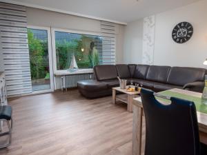 uma sala de estar com um sofá e uma mesa em Apartment Niki by Interhome em Norddeich