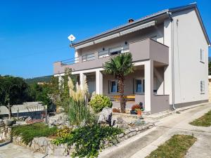 una casa blanca con una palmera delante de ella en Apartment Šegulja-1 by Interhome en Jadranovo