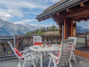a table and chairs on a balcony with mountains at Chalet Belle Vue by Interhome in Nendaz